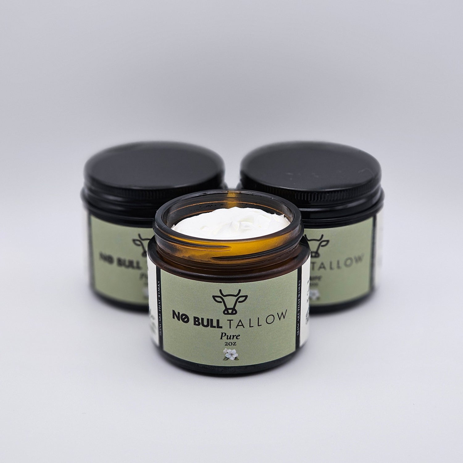 Three jars of Pure No Bull Tallow on a white background