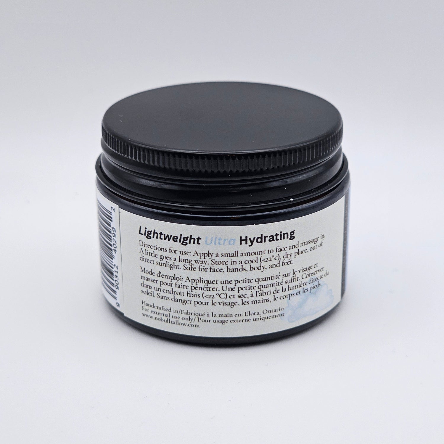 Cosmetic jar with black lid and white label on a light gray background