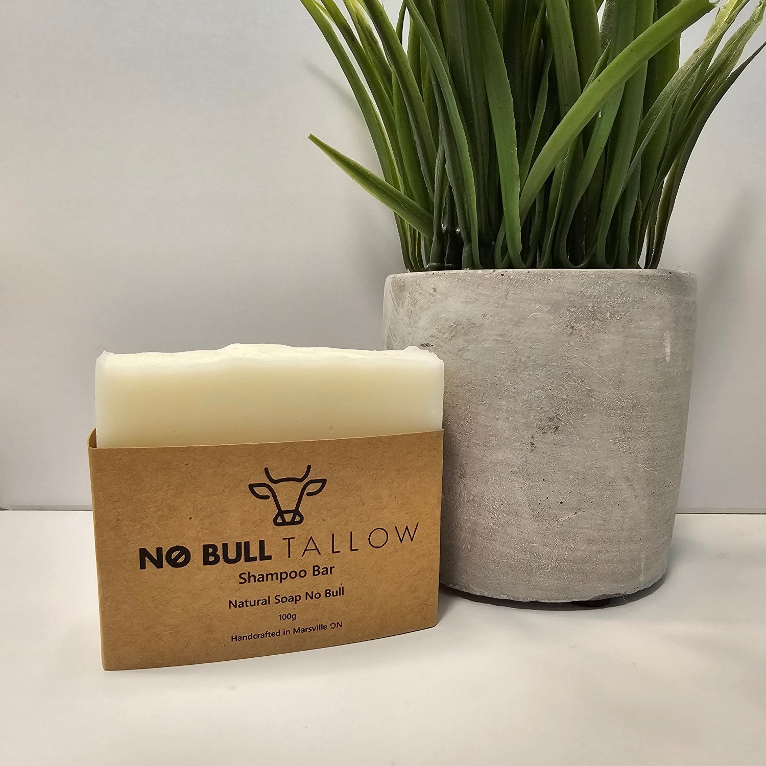 Natural tallow shampoo bar beside green plant on bathroom counter – eco-friendly solid shampoo for scalp balance