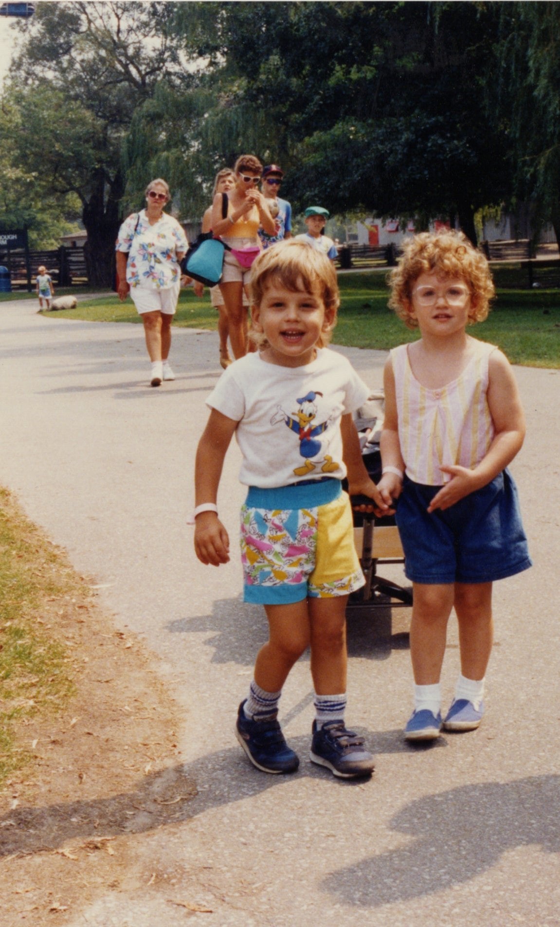 A picture of the founders of no bull tallow walking in a park with a wagon as kids