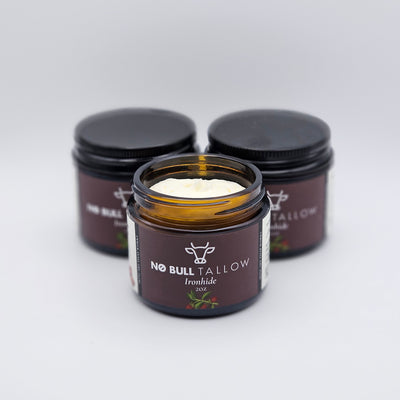 three sxmall jars of Ironhide, natural tallow body butter with brown labels on a white background
