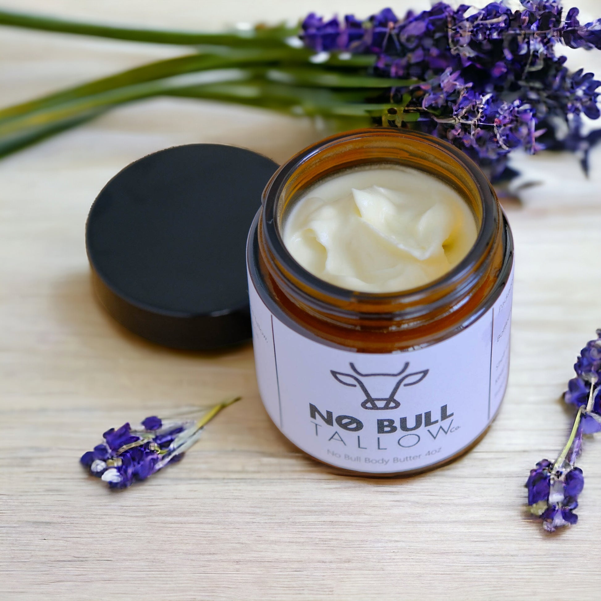 tallow body butter with lavender flowers around jar