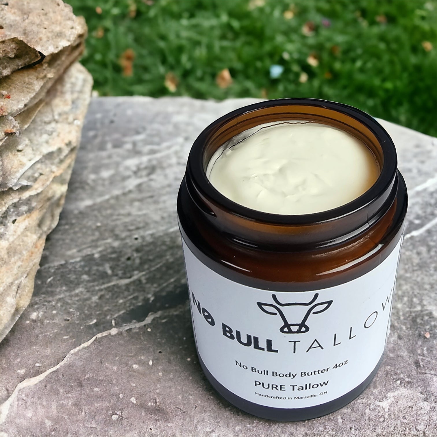 pure tallow jar open on stones