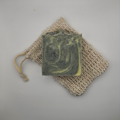 Starry Night tallow soap bar resting on hemp soap saver bag – calming lavender and cedarwood soap on grey background
